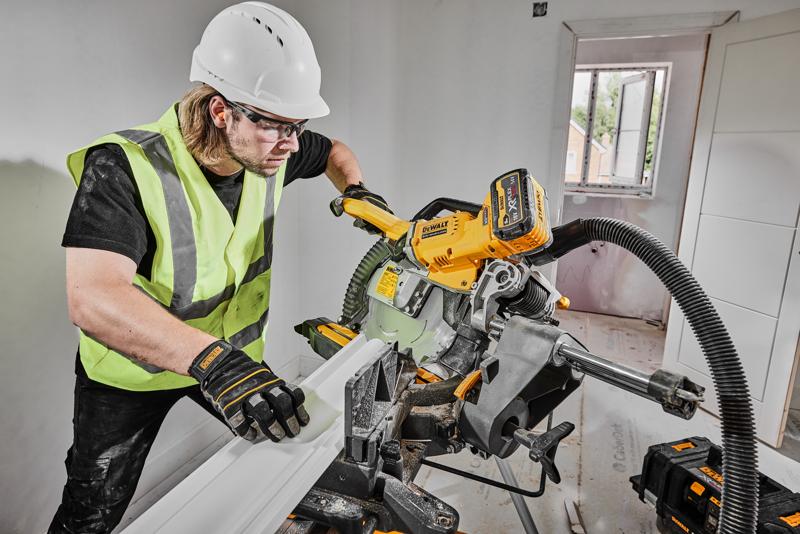 DEWALT saw DCS781X2-QW, DCS781X2 in use on construction site by worker in safety gear.