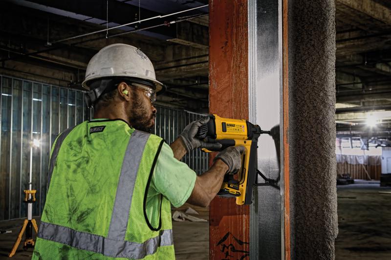 Worker using DEWALT tool, SKUs DGN845D1-QW and DGN845D1, on a metal frame at construction site.