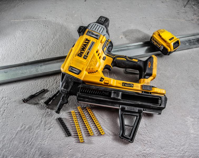 DEWALT DCN890P2 battery nailer with accessories and fasteners on a concrete surface.