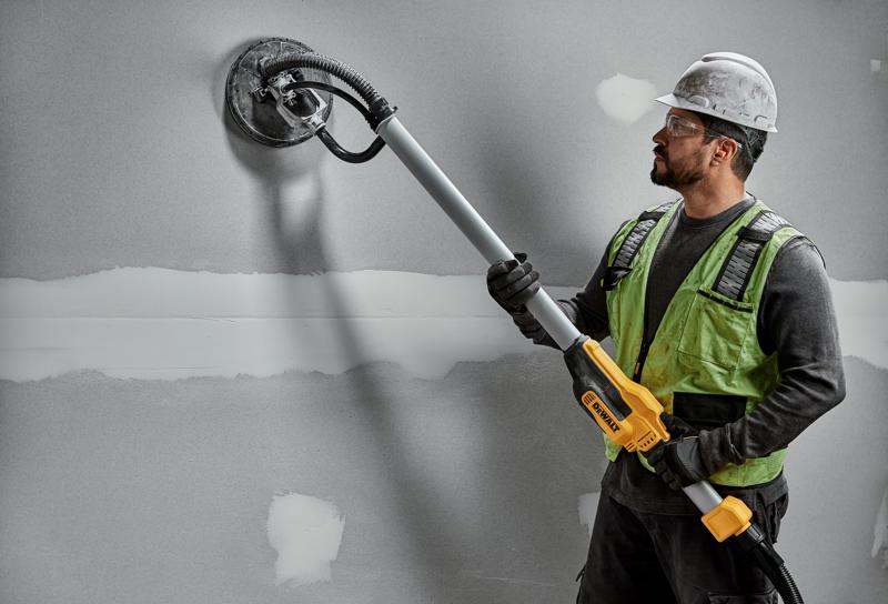 Worker uses DEWALT DWE7800, DWE7800-QS wall sander on drywall. Photography product shown in action.